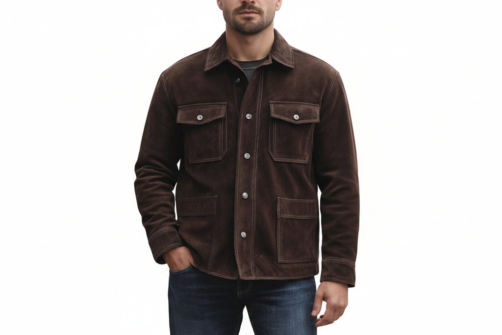 A man wearing a dark brown suede jacket with silver snap buttons and flap chest pockets, paired with blue jeans, against a plain white background.