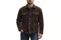 A man wearing a dark brown suede jacket with silver snap buttons and flap chest pockets, paired with blue jeans, against a plain white background.