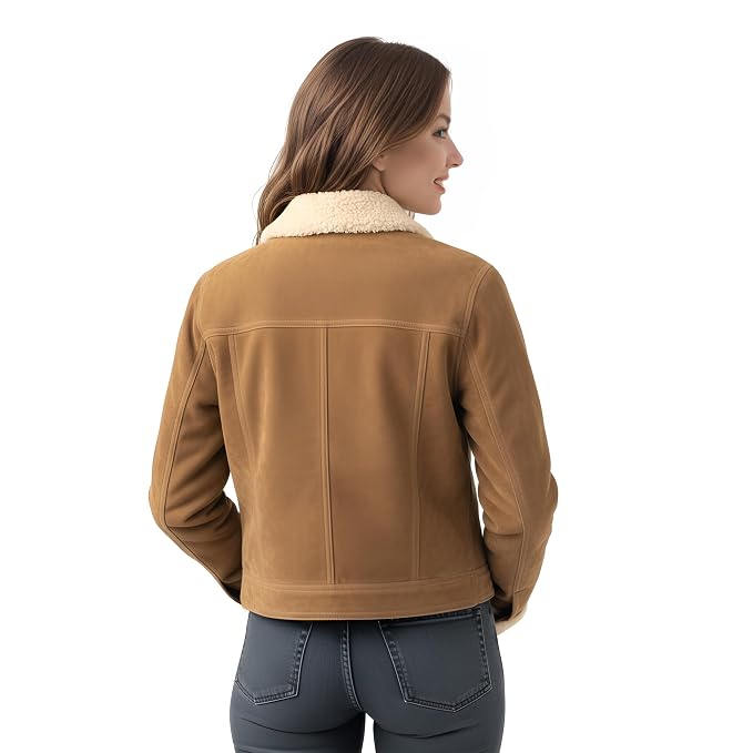 A woman shown from the back wearing a cropped tan shearling jacket with a cream-colored collar, paired with dark gray jeans, against a plain white background.