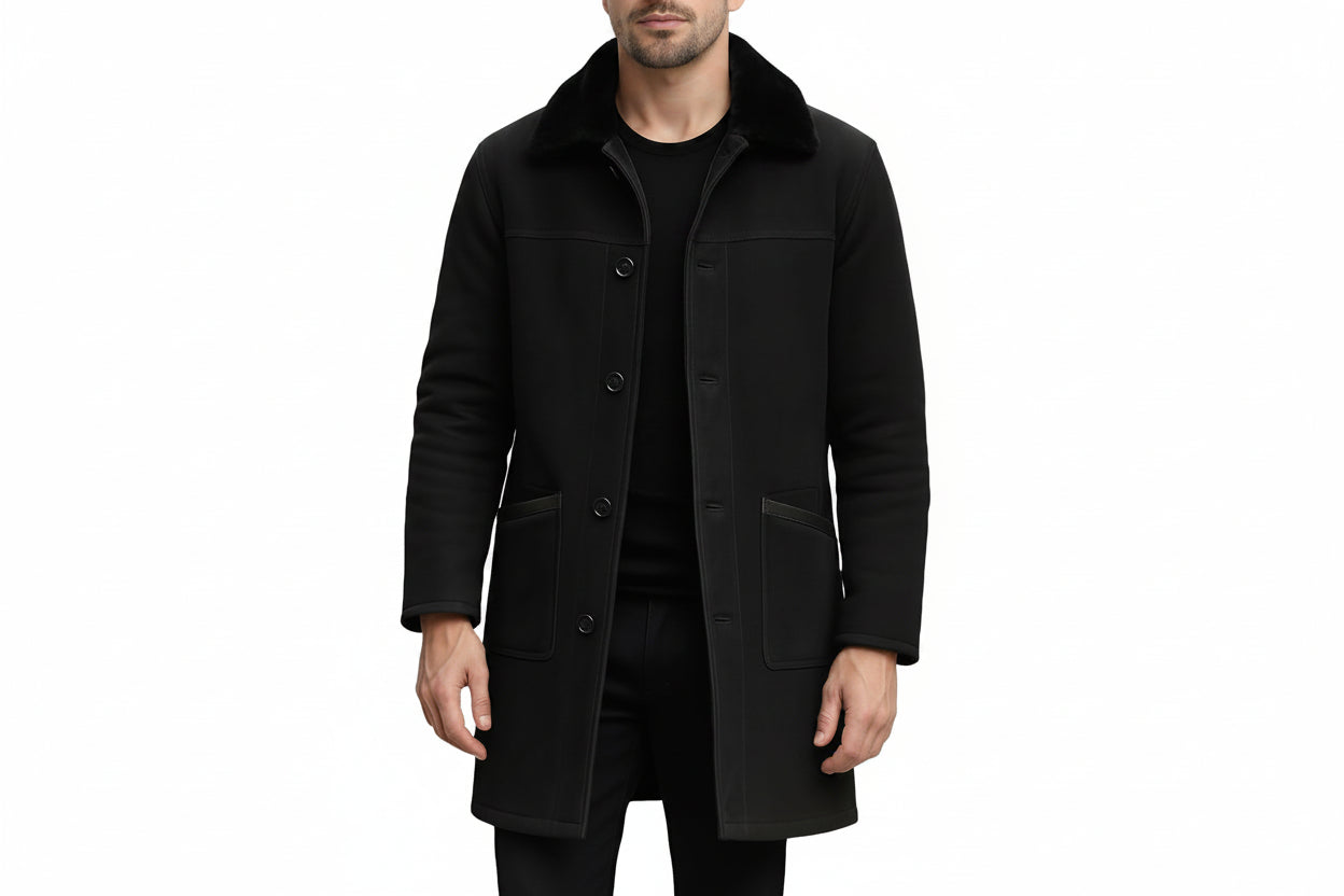 Men's crown edge elegant genuine soft suede real leather long coat in jet black featuring a plush tonal black fur fold-over collar, single-breasted button front closure, large hip patch pockets, long fitted sleeves, knee-length cut, and custom made-to-measure fitting across the UK, USA, and Australia.