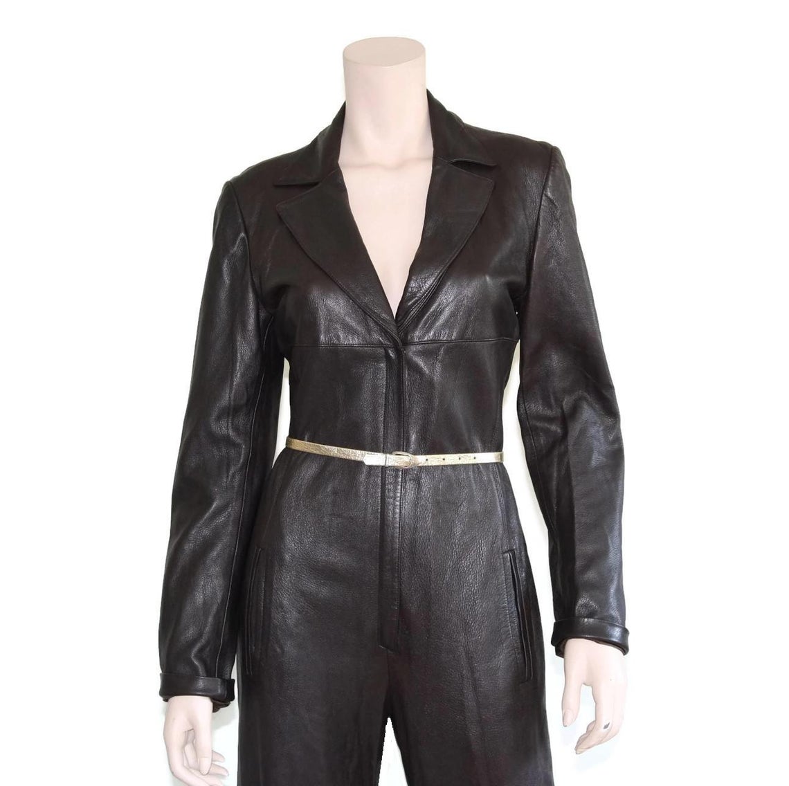 Elara Edge women's dark espresso black genuine lambskin leather jumpsuit featuring blazer-style notch lapels, deep V-neckline, long sleeves, slender metallic waist belt, straight wide-leg trousers, side pockets, and custom made-to-measure fitting across the UK, USA, and Australia.side