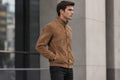 Side view of the faded tan Iron Howl Suede Leather Jacket featuring a stand collar, button closure, and ribbed knit trim.