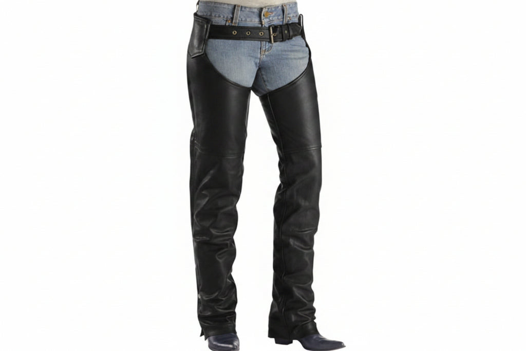 Black leather chaps worn over blue jeans with a black leather belt, shown on a model from the waist down against a white background.