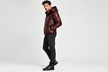 Side view of a man wearing the Night Forge Lambskin Leather Fashion Jacket featuring an attached hood, full-zip front, and quilted body.