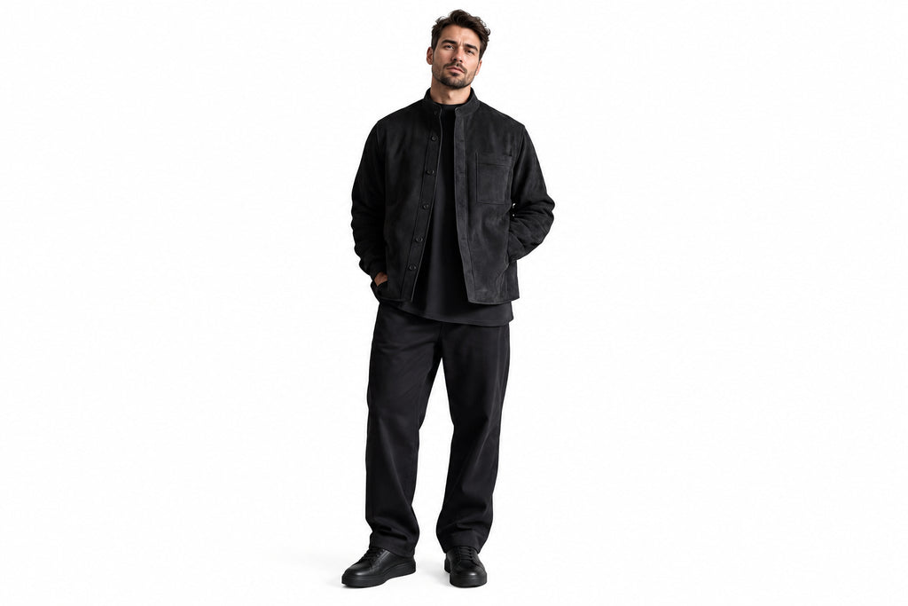 Side view of a man wearing the black Opulent Grain Cafe Racer Suede Leather Jacket featuring a stand collar, button closure, and chest pocket.