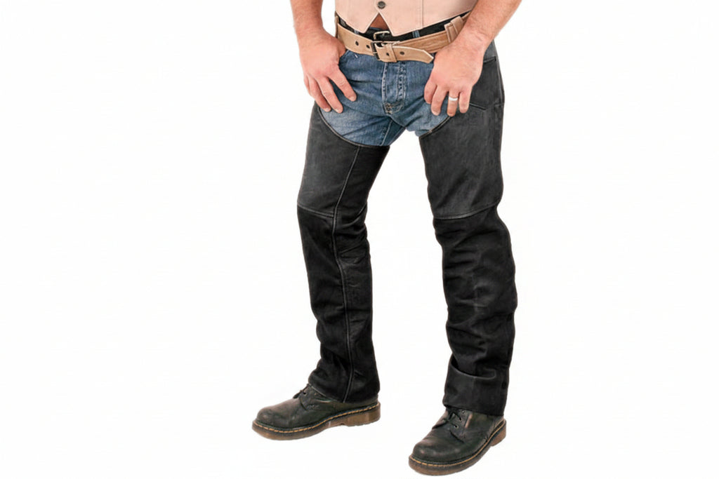 Men's raven edge premium genuine soft lambskin real leather motorcycle riding chaps in matte black featuring full-length outer side leg zippers, bottom ankle snap-button closures, articulated knee seam paneling, low-slung open crotch over-jeans design, and custom made-to-measure fitting across the UK, USA, and Australia.