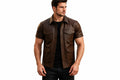 Front view of a man wearing the brown short-sleeve Savage Forge Iconic Lambskin Runway Leather Jacket featuring a shirt collar and utility pockets.