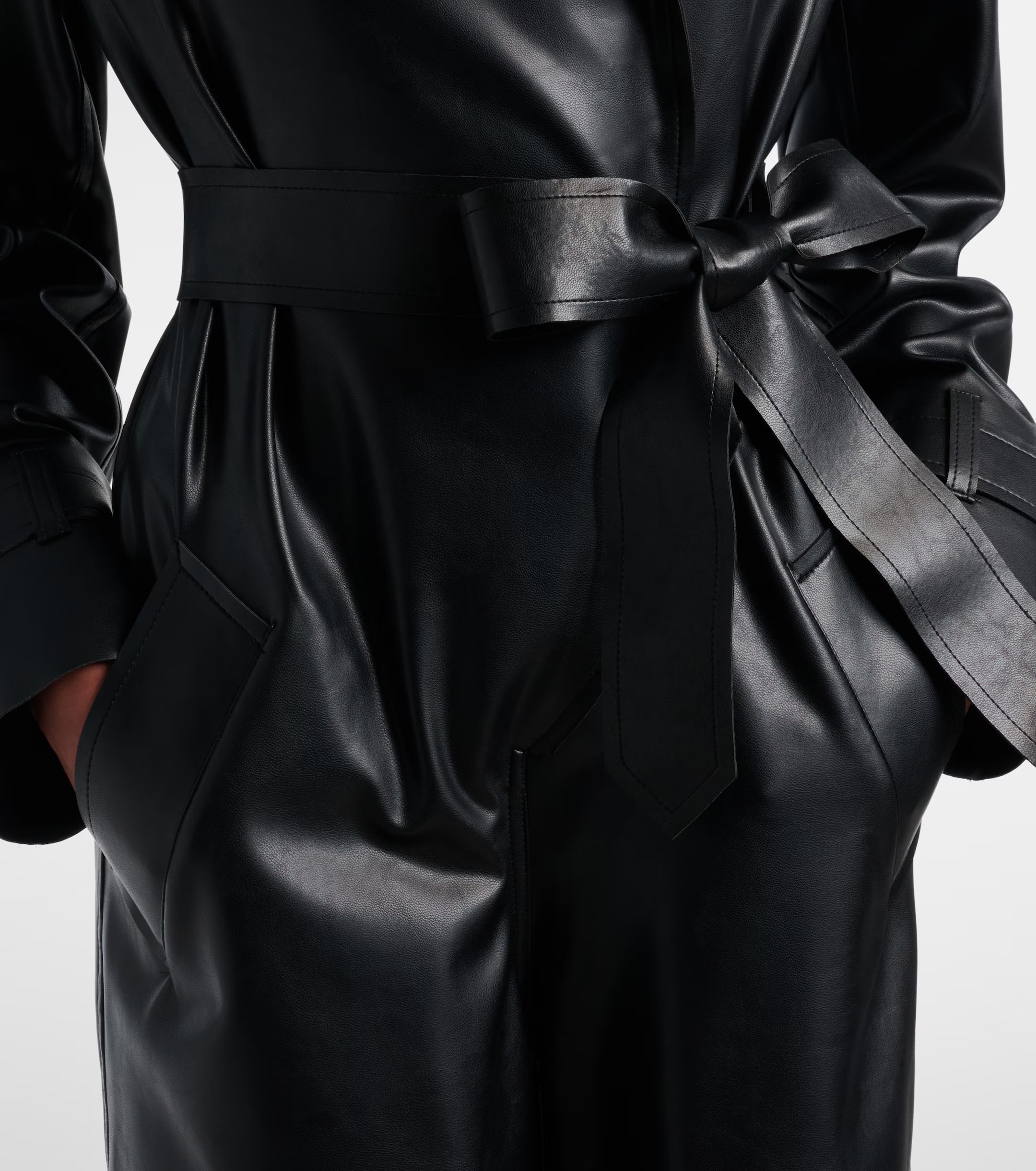 Sienna Noir women's jet black genuine Nappa lambskin leather jumpsuit featuring a trench coat style notch collar, chest storm flap, shoulder epaulettes, self-tie leather waist belt, wide-leg trousers, and custom made-to-measure fitting across the UK, USA, and Australia.1