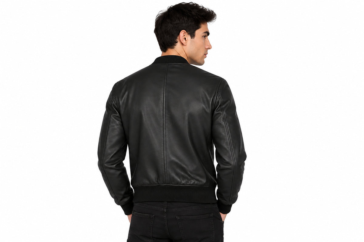 Back view of a man wearing the smoked tobacco leather jacket featuring a ribbed knit collar, full-zip front, and quilted shoulders.