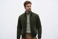 Front view of a man wearing the olive green Timeless Edge Olive Green Suede Leather Jacket featuring diamond quilting and a stand collar.