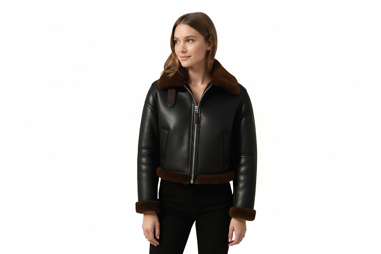 Urbanclad women's cropped matte black genuine soft lambskin real leather aviator jacket featuring plush dark brown shearling fur collar with leather throat buckle latch, front metal zip closure, side welt pockets, fur-trimmed cuffs and hem, long fitted sleeves, and custom made-to-measure fitting across the UK, USA, and Australia.