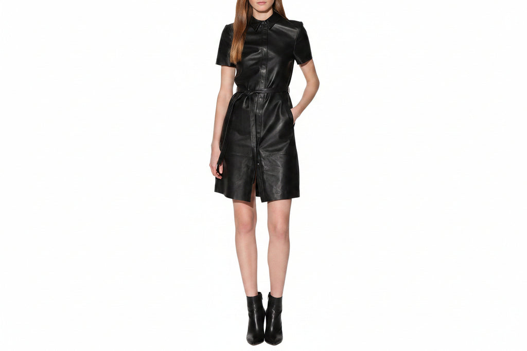 Vesper Noir women's jet black genuine lambskin leather jumpsuit featuring a classic point collar, concealed front placket, short sleeves, self-tie leather waist belt, side pockets, structural horizontal seamwork, and custom made-to-measure fitting across the UK, USA, and Australia.
