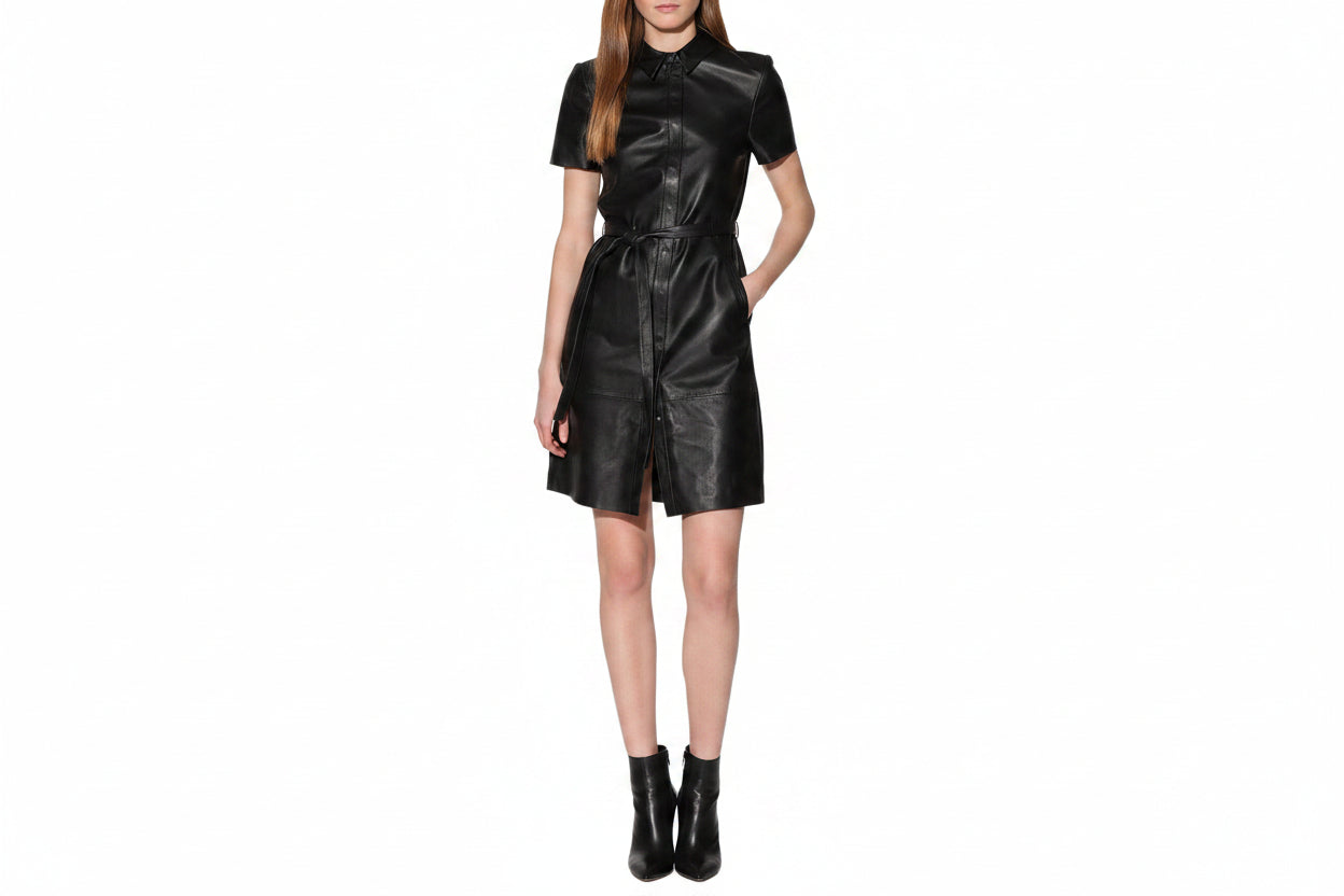 Vesper Noir women's jet black genuine lambskin leather jumpsuit featuring a classic point collar, concealed front placket, short sleeves, self-tie leather waist belt, side pockets, structural horizontal seamwork, and custom made-to-measure fitting across the UK, USA, and Australia.