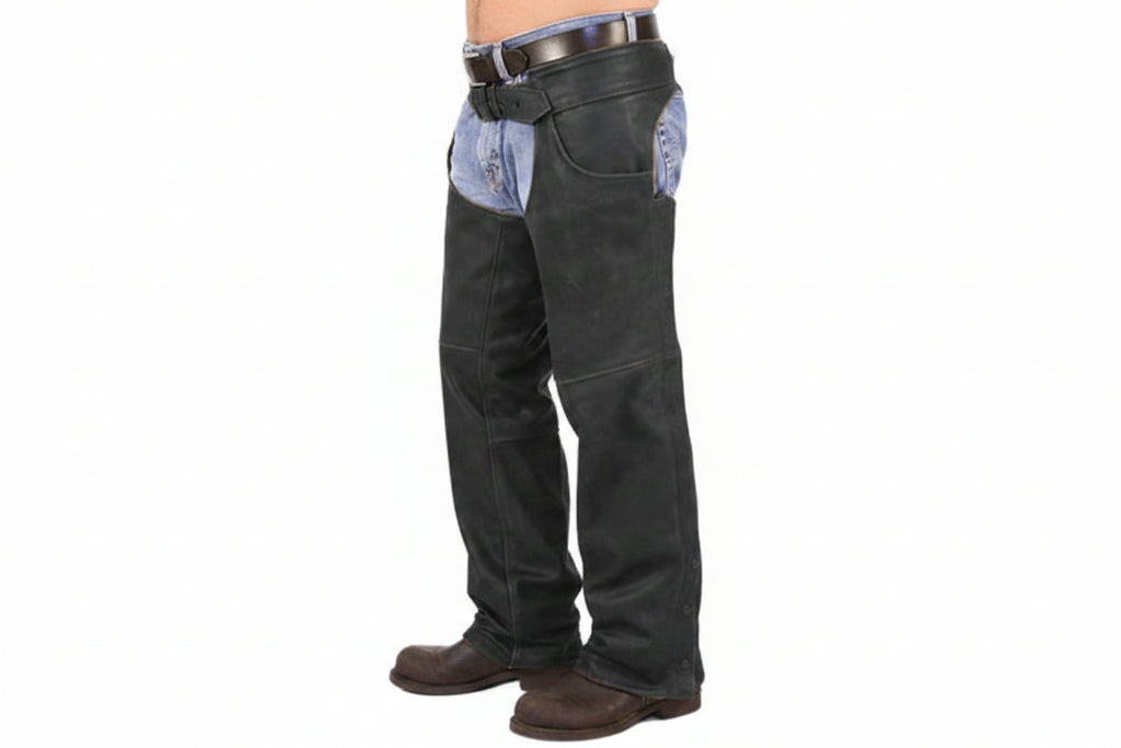 Men's wild west heritage genuine soft lambskin real leather motorcycle and horse riding chaps in matte black featuring an integrated waist belt with buckle, zipperless upper hip curved open stash pocket, smooth leg panels, bottom ankle snap-button closures, open crotch over-jeans design, and custom made-to-measure fitting across the UK, USA, and Australia.